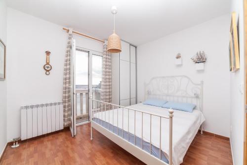 a white bedroom with a bed and a balcony at Beachfront First Line View in Sveti Stefan