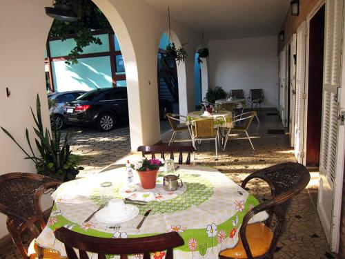 a table and chairs with a table and a car parked at Pousada Omnimare in Ubatuba
