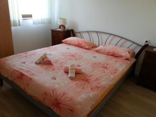 een slaapkamer met een bed met roze lakens en kussens bij Apartment Drenovica in Pula