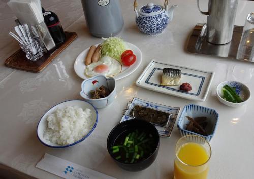 une table avec des plaques alimentaires et des bols de riz dans l'établissement Hotel La Montagne Furuhata, à Hakuba