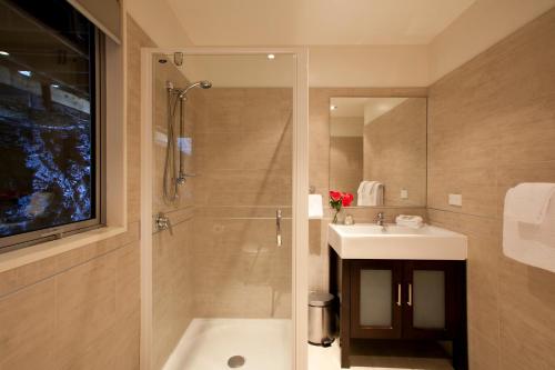 ein Badezimmer mit Dusche, Waschbecken und Badewanne in der Unterkunft White Peaks Villa in Queenstown