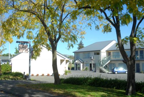 a row of houses and trees on a street at Village Motel in Havelock North
