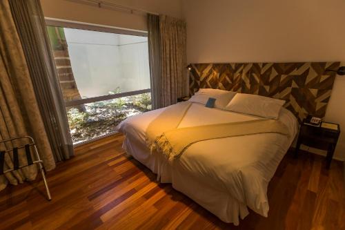a bedroom with a bed and a large window at Aruma Hotel Boutique in Arica