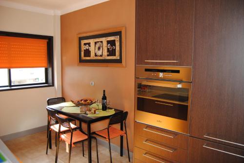 a kitchen with a table and a stove top oven at Diamante Azul Barra Beach Apartment in Praia da Barra