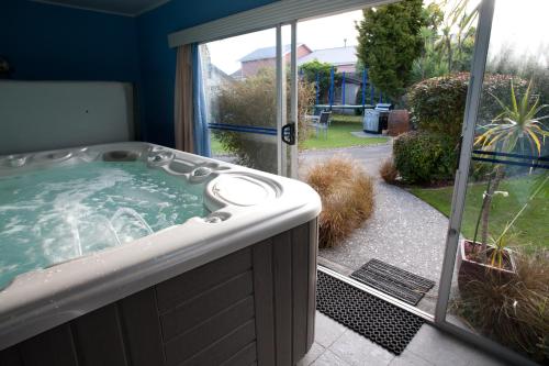 a jacuzzi tub in a yard next to a window at ASURE Colonial Lodge Motel in Napier