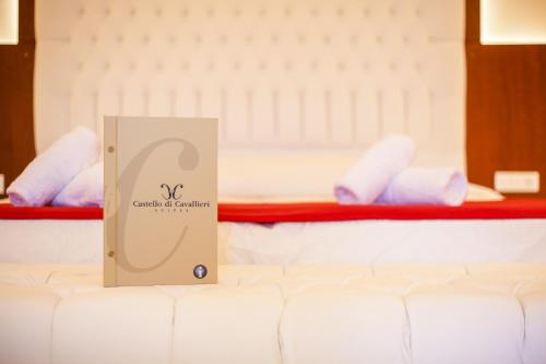 a sign sitting on top of a bed in a room at Castello Di Cavallieri Suites & Spa - Adults Only in Faliraki