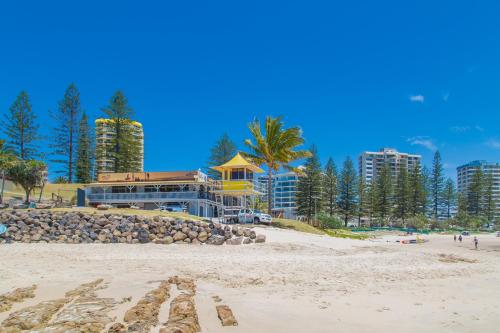 a view of a beach with buildings and palm trees at Columbia Beachfront Apartments on Rainbow Bay in Gold Coast