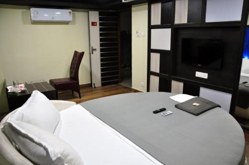 Dieses Zimmer verfügt über ein Bett mit einem TV und ein Bett der Marke sidx sidx sidx. in der Unterkunft Hotel Anandhiram Heritage in Kāraikāl