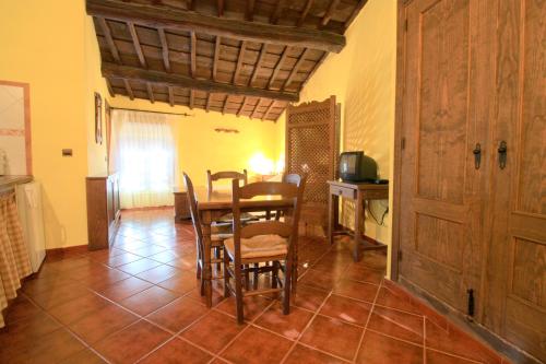 a dining room with a table and chairs and a television at La Boticaria Casa Rural Apartamento in Descargamaría