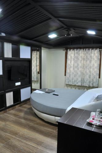 a bedroom with a large bed and a flat screen tv at Hotel Anandhiram Heritage in kāraikāl