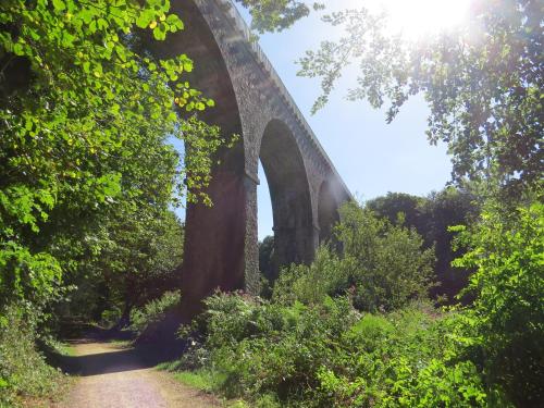 a bridge over a dirt road with a trail at Les Chambres de Kermenguy in Sibiril