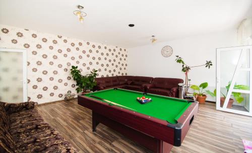 a living room with a pool table and a couch at Pensiunea Tinelu Brașov sacele in Braşov