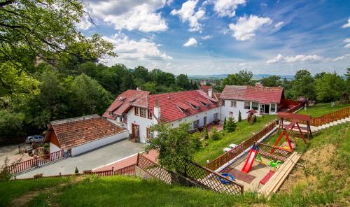une vue aérienne sur une grande maison avec des toits rouges dans l'établissement Pensiunea Tinelu Brașov sacele, à Braşov