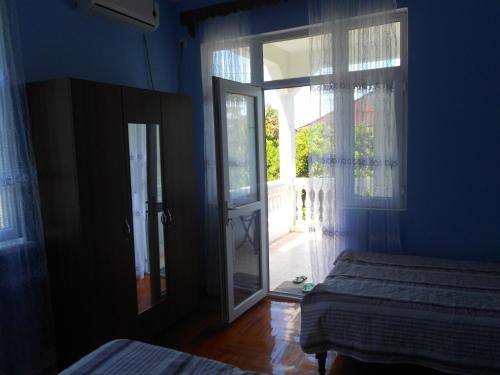 a blue room with two beds and a window at Marina kvariati in Kvariati