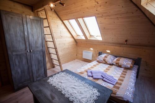 sypialnia na poddaszu z łóżkiem i drabiną w obiekcie Wiejski Zakątek nad Wigrami w mieście Rosochaty Róg