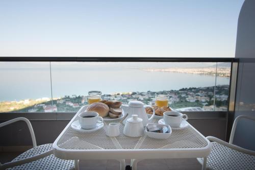 a table with a breakfast of coffee and pastries on it at Belvedere Hotel in Kalamata