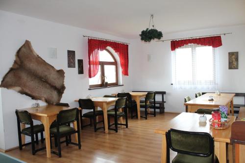 a dining room with wooden tables and chairs at Pokoje gościnne Kamińscy in Gliczarów