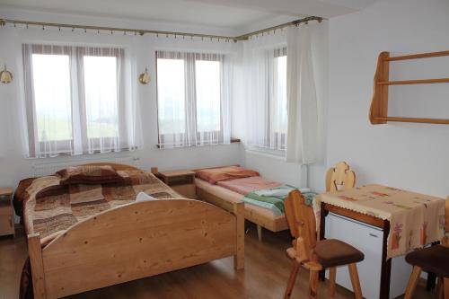 a bedroom with two beds and a table and chairs at Pokoje gościnne Kamińscy in Gliczarów