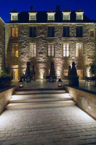 a large stone building with lights in front of it at Hôtel Restaurant de Bouilhac in Montignac