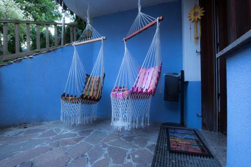 three hammocks hanging from a wall on a porch at Central Greenlife in Tarvisio