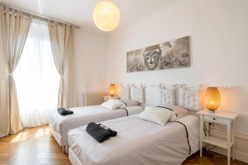 two beds in a room with two lamps and a window at Saxe And The City , Downtown Lyon in Lyon