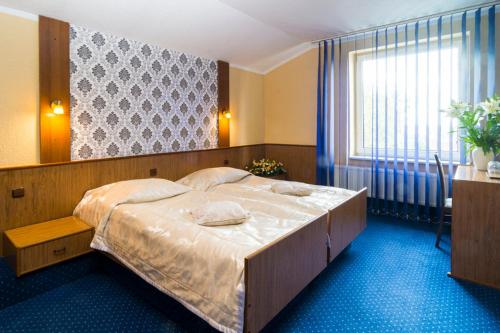 a bedroom with a large bed in a room at Hotel Victoria in Szczecin