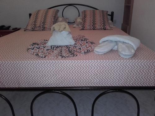 a bed with a stuffed animal sitting on top of it at Hotel Fotini in Kamena Vourla