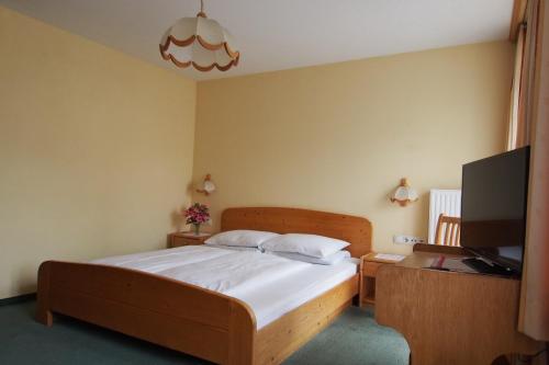 1 dormitorio con 1 cama y TV de pantalla plana en Gasthof Knappenwirt, en Tamsweg