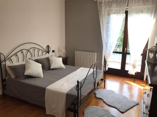 a bedroom with a bed and a large window at Villa Nicolai tra Mare e Montagna in Lettomanoppello