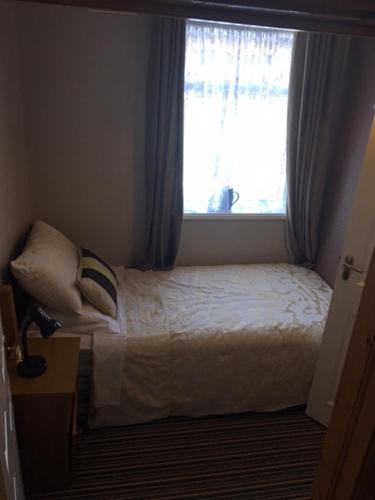 a small bedroom with a bed and a window at Coolalingo B&B in Drumgoff Bridge