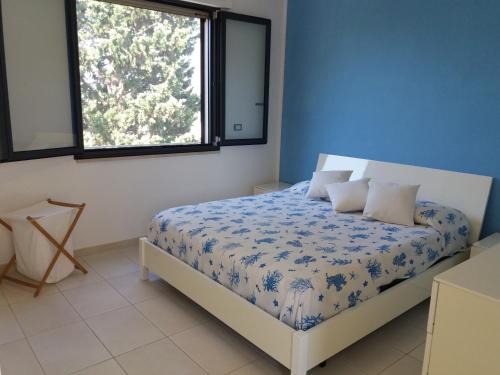 トッレ・ラピッロにあるCasa vacanze porto cesareoのベッドルーム1室(青と白の掛け布団付きのベッド1台付)