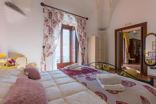 a bedroom with a large bed with a large window at Palazzotto in Ostuni