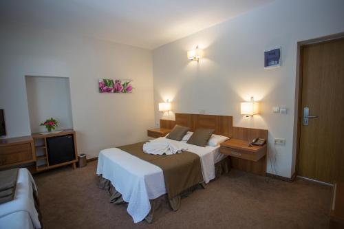 a hotel room with a bed and a television at Melis Hotel Kusadasi in Kusadası