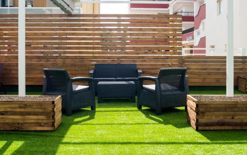 a patio with chairs and a table on the grass at Apartamentos Sol y Vera in Magaluf