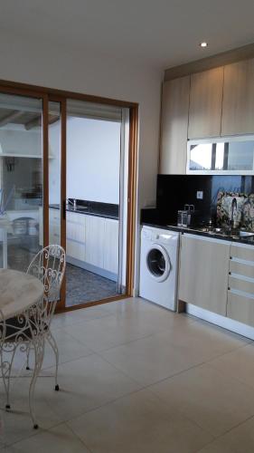 a kitchen with a washing machine and a table and a dining room at Casa São José by Pérola do Oceano in Manta Rota