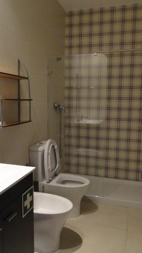 a bathroom with a toilet and a glass shower at Pérola do Oceano in Manta Rota