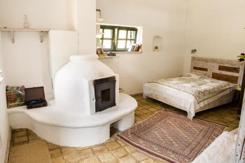 a white room with a fireplace and a bed at Henye holiday homes in Balatonhenye