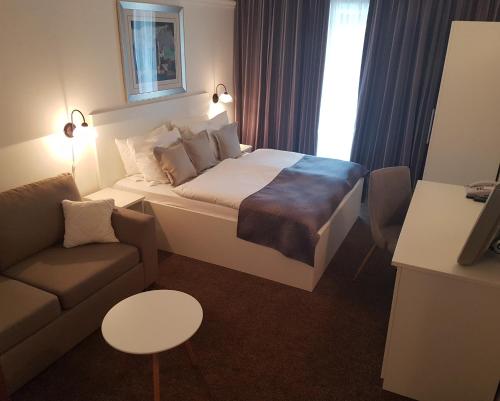 a hotel room with a bed and a couch at Hotel Argentum in Vrbnik