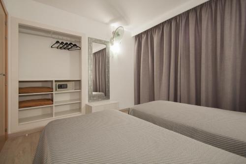 a hotel room with two beds and a mirror at Apartamentos Sol y Vera in Magaluf