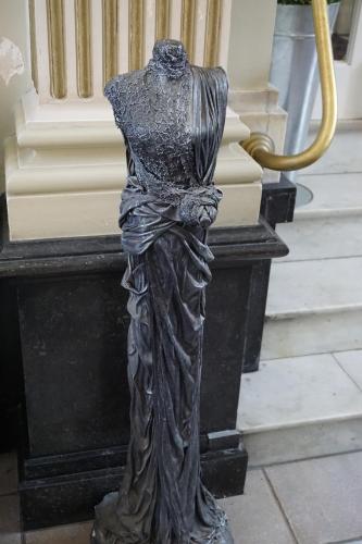 a bronze statue of a woman standing on a staircase at Hotel Asiris in Bruges