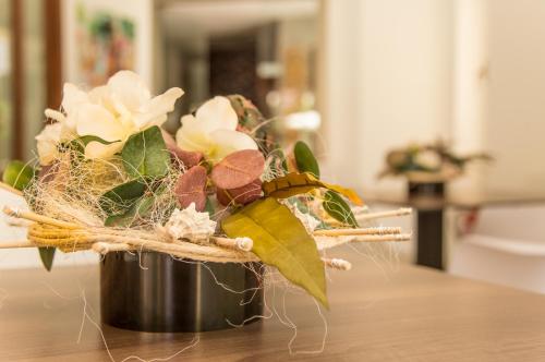 a flower arrangement in a pot on a table at Flacalco Hotel & Apartments in Cala Ratjada