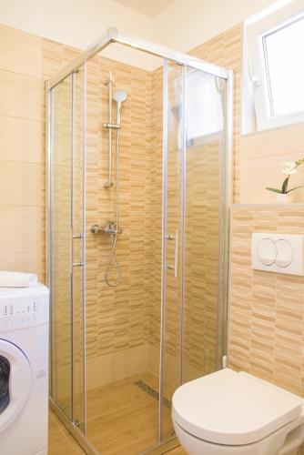 a shower stall in a bathroom with a toilet at Eni apartments BOL in Bol