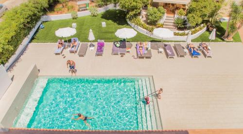 an overhead view of a swimming pool with people in the water at Flacalco Hotel & Apartments in Cala Ratjada