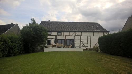 a large white house with a lawn in front of it at Vakantiehuis Le Colombage in Beauraing