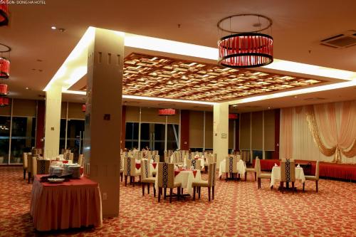 a banquet hall with tables and chairs and a chandelier at Sai Gon Dong Ha Hotel - a member of Saigontourist Group in Quảng Trị