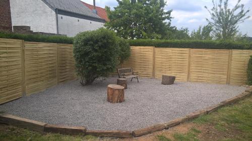 a garden with a bench and a tree and a fence at Vakantiehuis Le Colombage in Beauraing