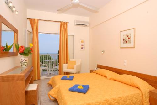 Un dormitorio con una cama con toallas azules. en Ipsos Beach Hotel, en Ýpsos