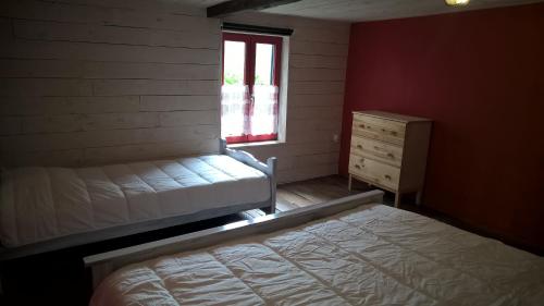 a bedroom with a bed and a window and a dresser at Vakantiehuis Le Colombage in Beauraing