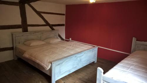 a bedroom with a bed in a room with red walls at Vakantiehuis Le Colombage in Beauraing