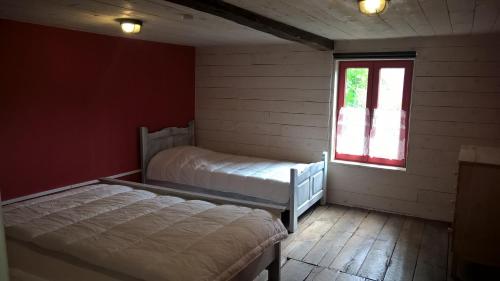 a bedroom with two beds and a window at Vakantiehuis Le Colombage in Beauraing